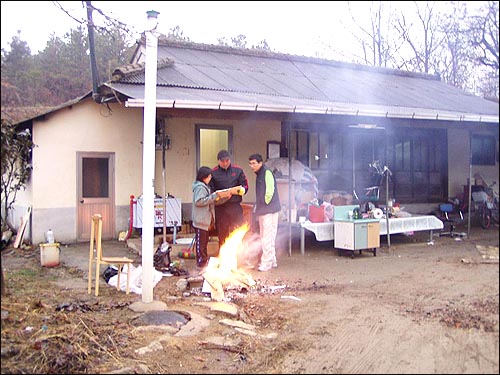 귀농 다음날 마당에서 불을 때고 있다. 